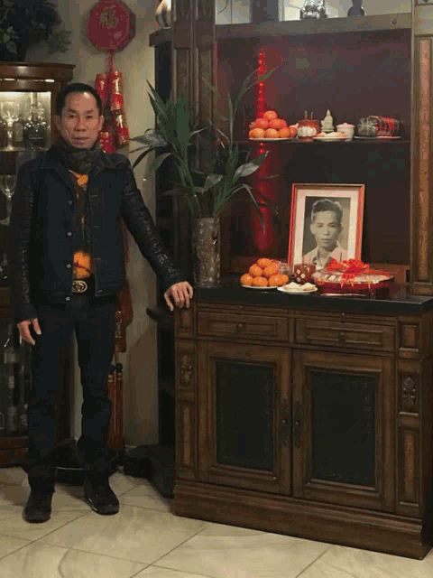 a man standing in front of a cabinet with a picture of a young man on it