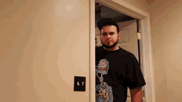 a man with a beard is standing in a doorway with a light switch that says lp