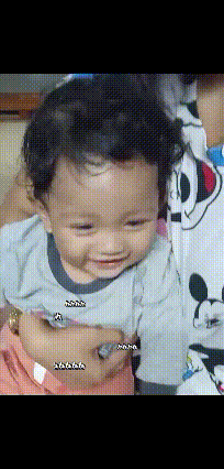 a baby wearing a mickey mouse shirt is being held by a woman