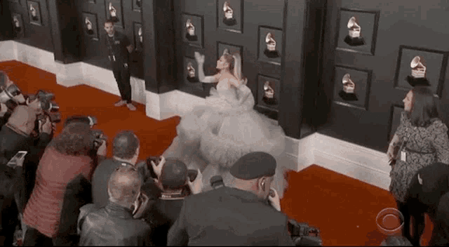 ariana grande is dancing on the red carpet at the grammy awards .