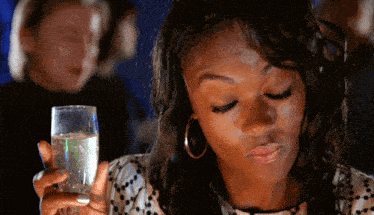 a woman is holding a glass of champagne in her right hand