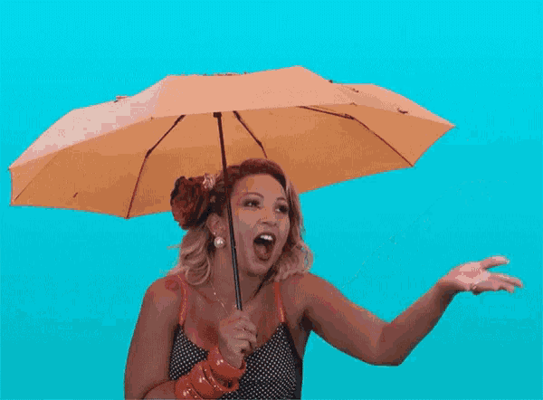 a woman is holding a yellow umbrella over her head and laughing