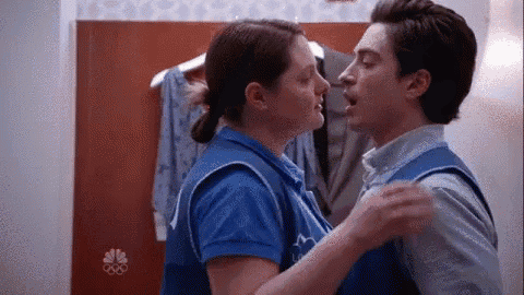 a man and a woman are kissing in a dressing room in a store .