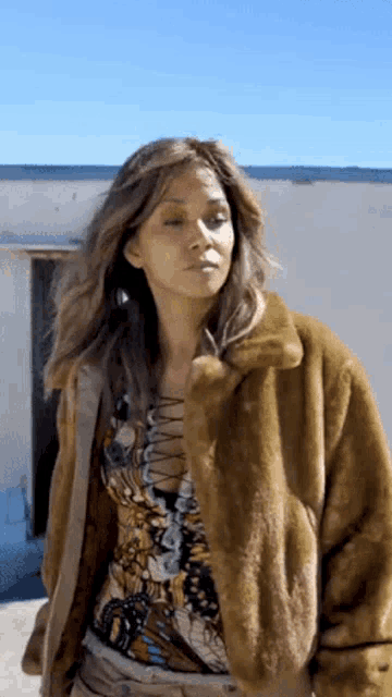 a woman is wearing a fur coat and a butterfly shirt