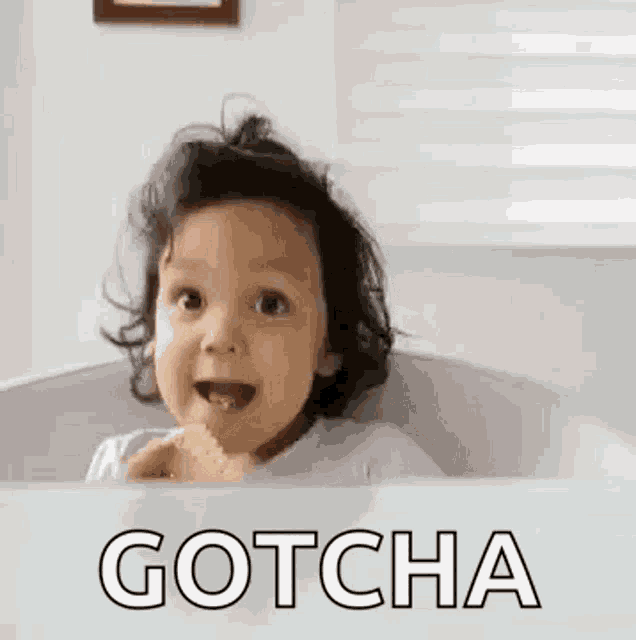 a baby is sitting in a bathtub eating a piece of food and making a funny face .
