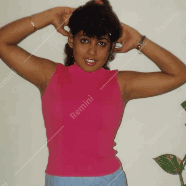 a woman wearing a pink tank top with remini written on the bottom