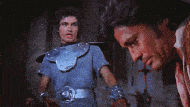 a man in a knight 's armor is holding a sword .