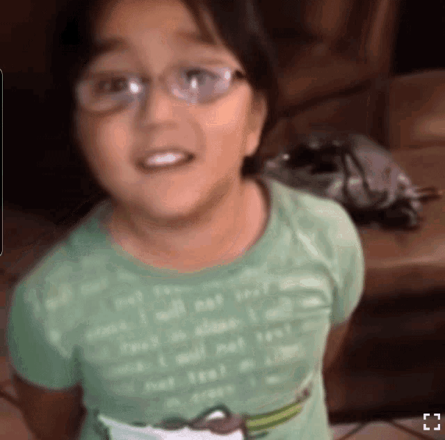 a young girl wearing glasses and a green shirt that says " trust "