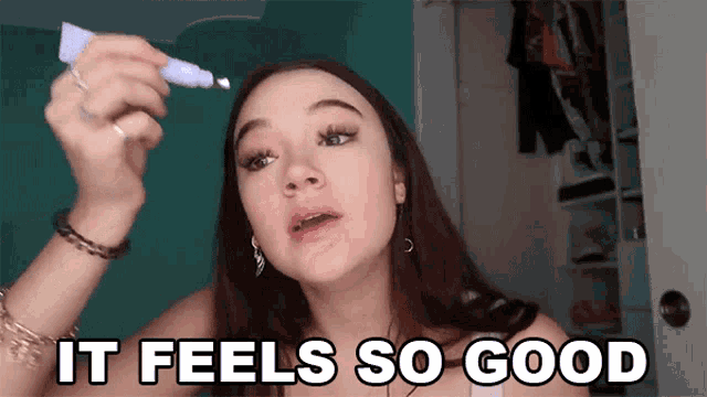 a woman is holding a tube of cream in her hand and says " it feels so good "