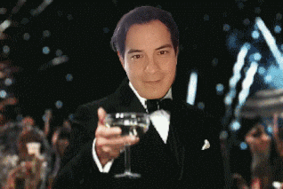 a man in a tuxedo holds up a glass of wine