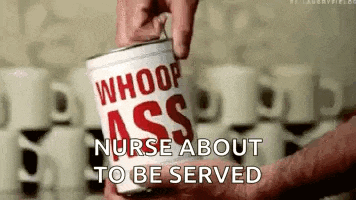 a person is holding a can of whoop ass soup .