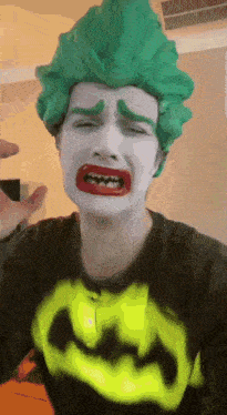 a man wearing a green wig and a batman shirt is crying