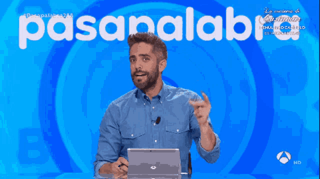 a man in a blue shirt stands in front of a blue background that says pasapalabra