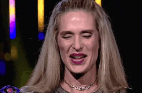 a woman with blonde hair and purple lipstick is smiling