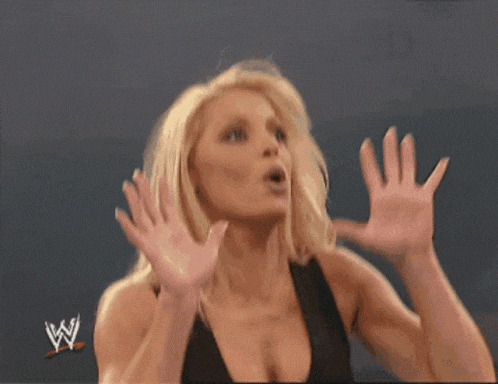 a woman in a wrestling ring with the letter w on the bottom