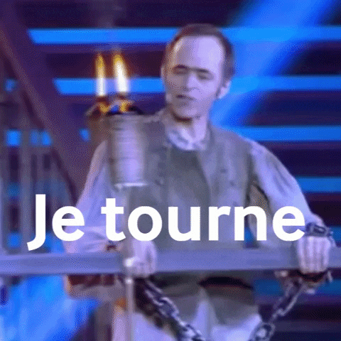 a man is chained to a pole with the words je tourne written above him .