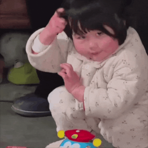 a baby playing with a toy that says ' dora ' on it