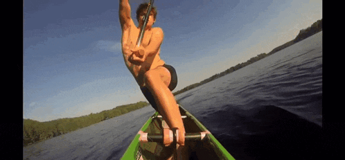 a man in a green canoe with a paddle in his hand