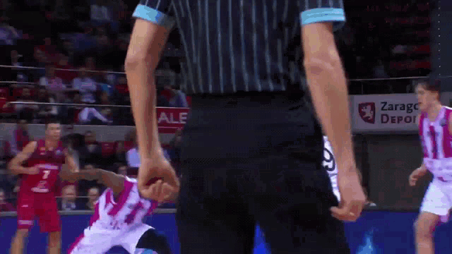 a referee stands in front of a sign that says zaragoza depoi