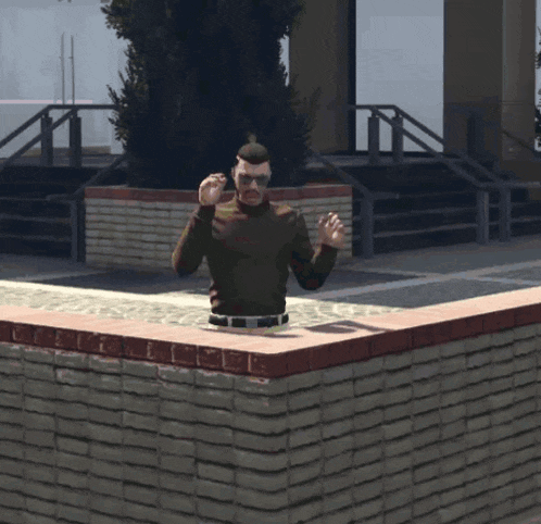 a man in a brown sweater is standing on a brick wall with his arms outstretched