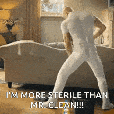 a man in white underwear is standing in front of a couch and says i 'm more sterile than mr clean .