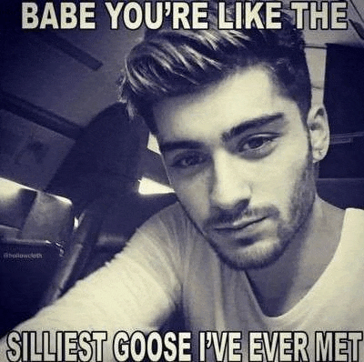 a black and white photo of a young man with a beard taking a selfie .
