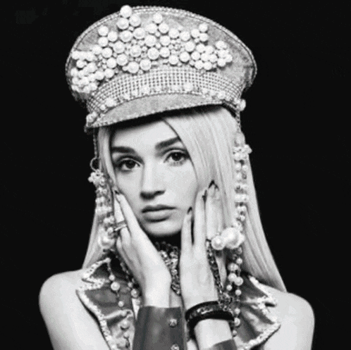 a woman wearing a hat with pearls on it