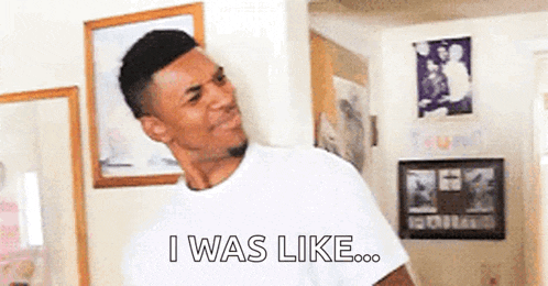 a man in a white shirt is standing in a room and saying `` i was like ... ''