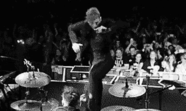 a man is dancing on a stage in front of a crowd of people .