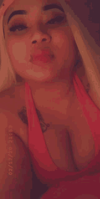 a close up of a woman 's face with a tattoo on her chest
