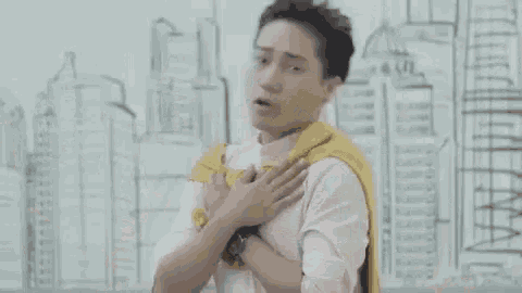 a man wearing a yellow scarf around his neck is dancing in front of a drawing of a city .