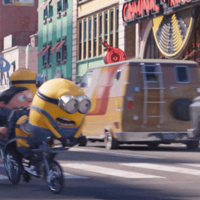 a minion is riding a bike down a street in front of a sign that says carnival