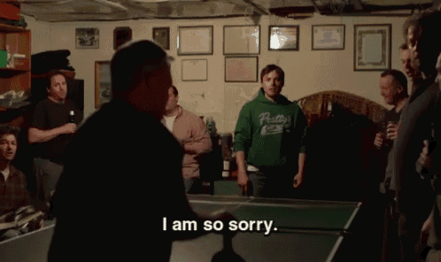 a man wearing a pretty sweatshirt says i am so sorry while playing ping pong