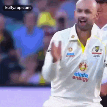 a man in a white shirt with the word energy on it is dancing on a soccer field .