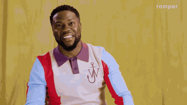a man with his arms outstretched is wearing a red white and blue shirt with an anchor on the front