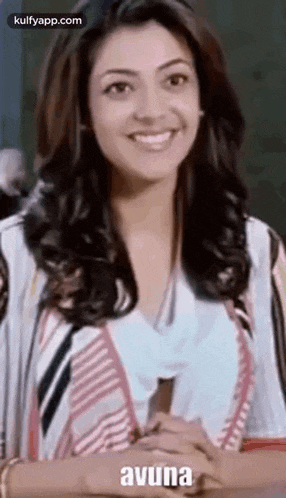 a woman is smiling while holding a pen in her hand .