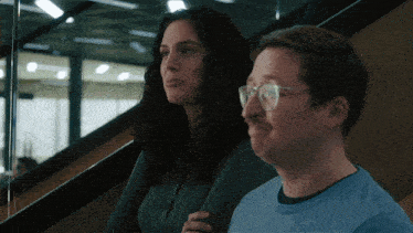 a man and a woman sitting on stairs looking at something
