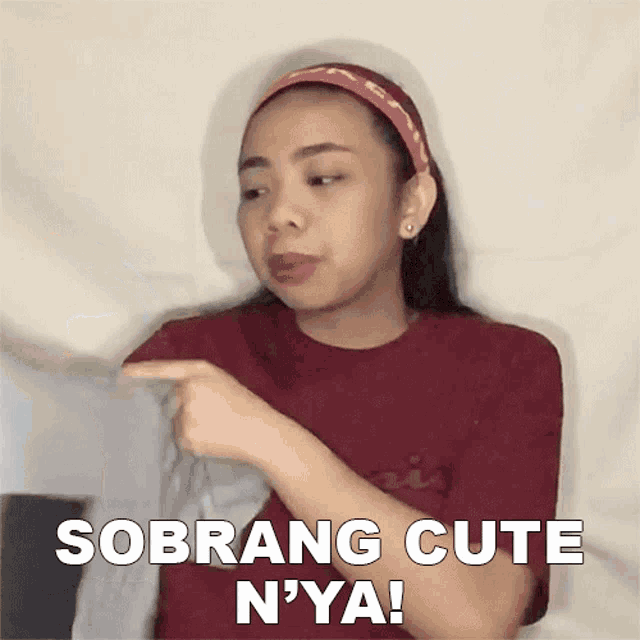 a woman in a red shirt is pointing at something and says " sobrang cute n'ya ! "
