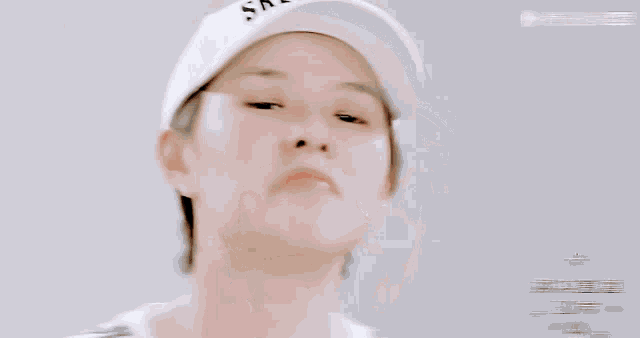 a woman wearing a skechers hat looks at the camera
