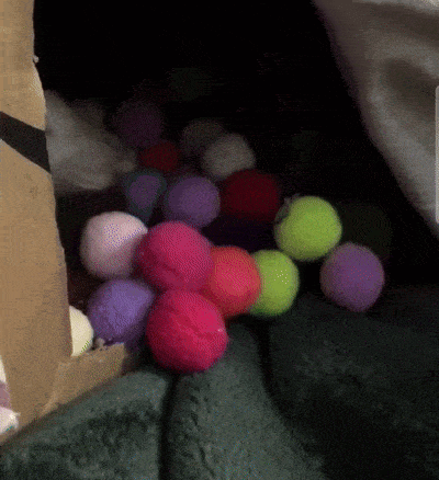 a bunch of colorful pom poms are laying on a blanket