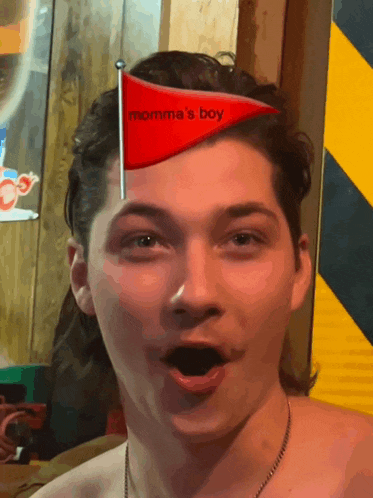 a man wearing a red hat that says momma 's boy on it