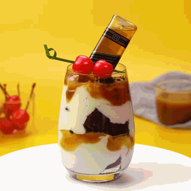 a glass of ice cream with a cherry on top and a bottle that says 12