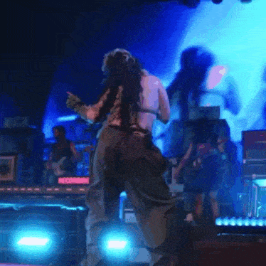 a woman is dancing on a stage in front of a screen that says recording