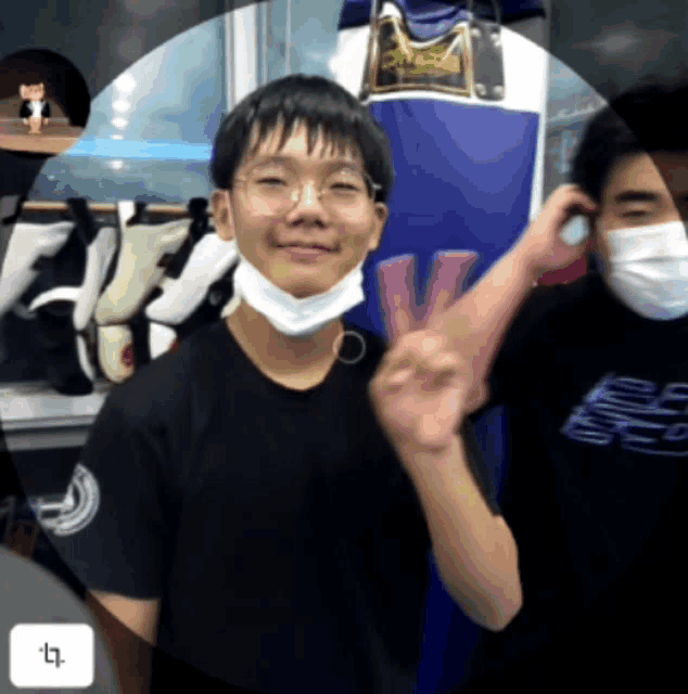 a man wearing a mask and a black shirt with the letter t on it