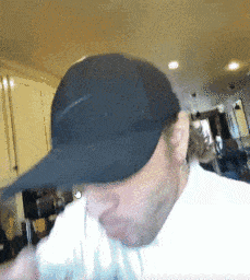 a man wearing a black hat is drinking from a bottle