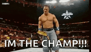 a man in a wrestling ring is holding a championship belt and says i 'm the champ