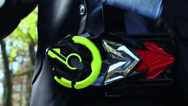 a person wearing a black suit has a green and red object on their waist with the letter c on it