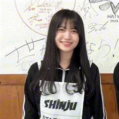 a girl with long black hair is wearing a shirt that says shinju and smiling .