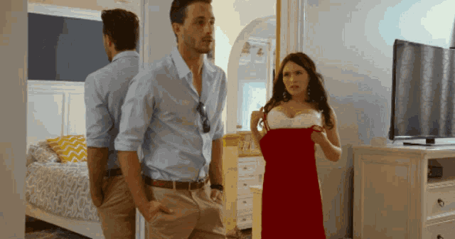 a man and a woman are standing in a bedroom