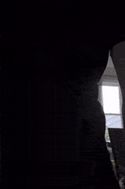 a man in a black t-shirt is standing in a living room